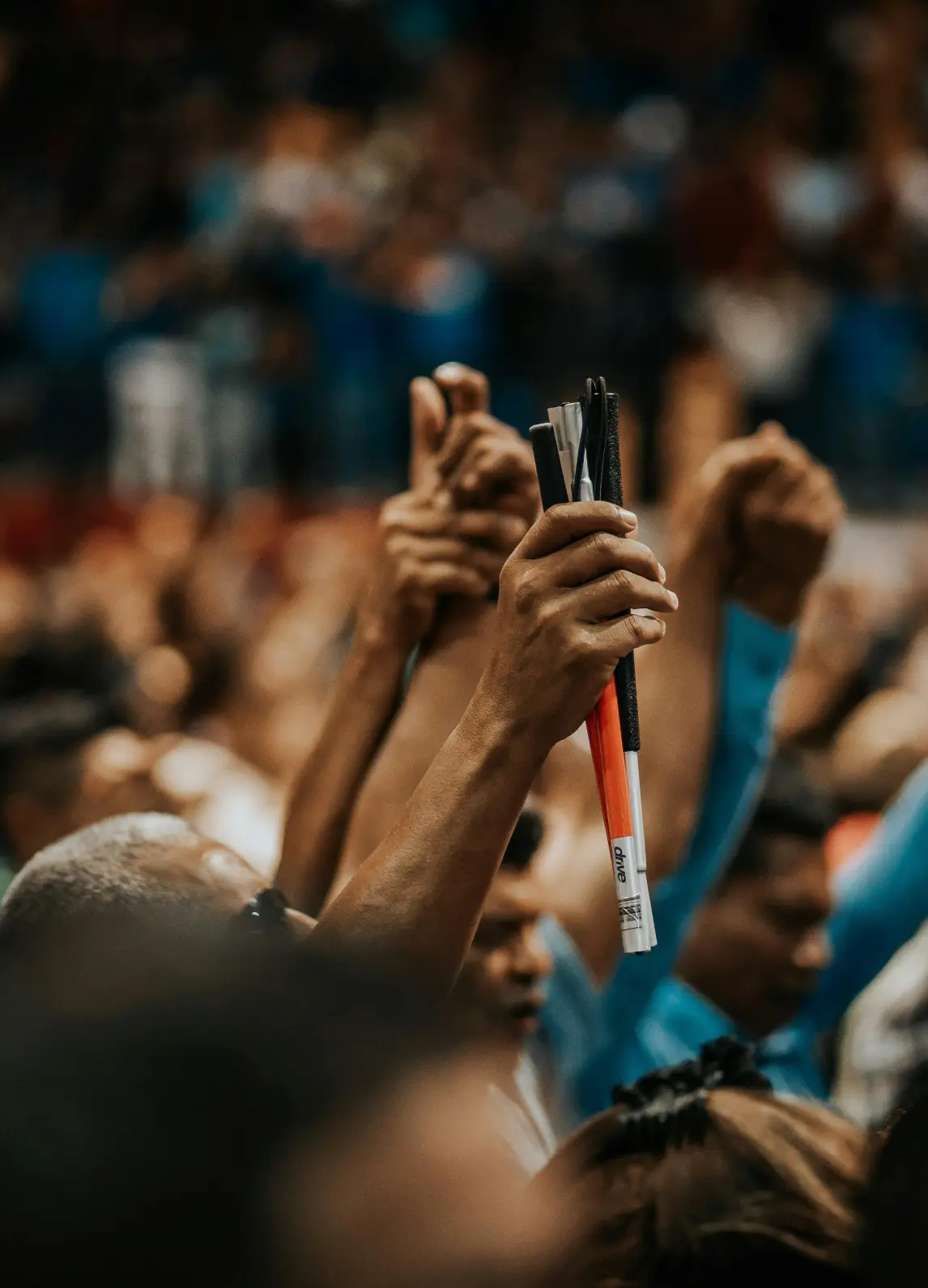 Close-up shot of two hands grasping each other and raised in the air during praise and worship